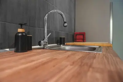 a kitchen sink with a faucet on a wooden counter at Beautiful apt in Glyfada Center, Papandreou Street in Athens