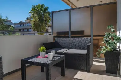a patio with a chair and a table on a balcony at Beautiful apt in Glyfada Center, Papandreou Street in Athens