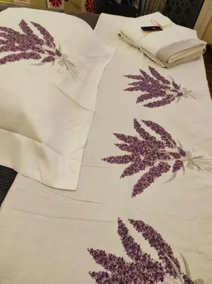 a bed with white sheets with purple leaves on it at Studio apartment with all amenities in Kolonaki in Athens