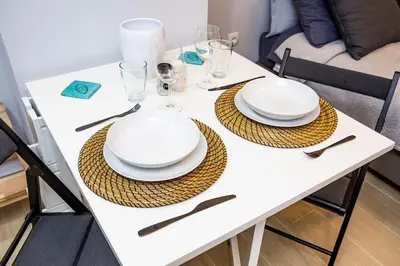 a white table with plates and utensils on it at Studio apartment with all amenities in Kolonaki in Athens