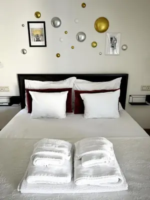 a white bed with three white towels on it at Sky Apt Unique, Spotless, 2BR, 2BA, Stunning View in Athens