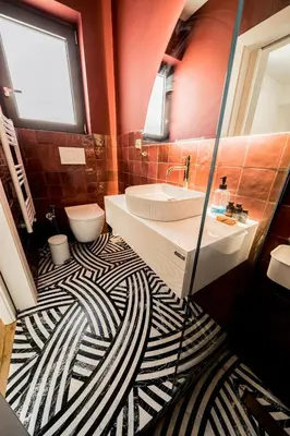 a bathroom with a black and white patterned floor at Sky Apt Unique, Spotless, 2BR, 2BA, Stunning View in Athens