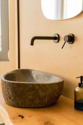 a bathroom with a stone sink on a counter at Sky Apt Unique, Spotless, 2BR, 2BA, Stunning View in Athens