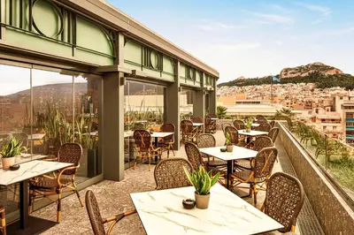 a restaurant with tables and chairs on a balcony at Zeus Essence Athens Central, former Athens Key in Athens