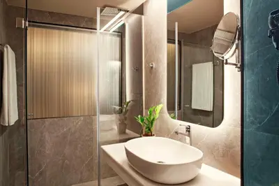 a bathroom with a sink and a glass shower at Zeus Essence Athens Central, former Athens Key in Athens
