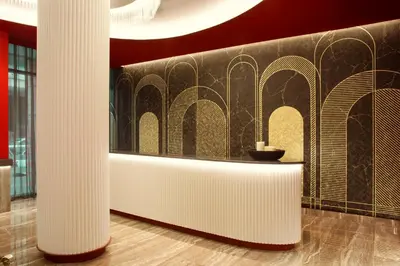 a lobby with columns and a wall with a table at Zeus Essence Athens Central, former Athens Key in Athens