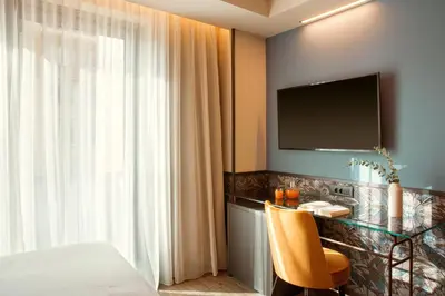 a bedroom with a bed and a desk with a television at Zeus Essence Athens Central, former Athens Key in Athens