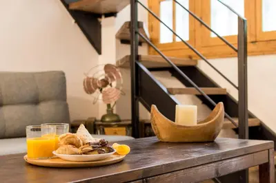 a table with a plate of food and a glass of orange juice at Stoa Kairi Loft B in Athens