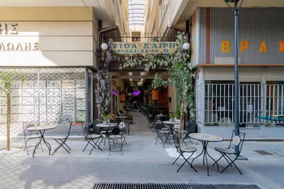 a group of tables and chairs in a building at Stoa Kairi Loft A in Athens