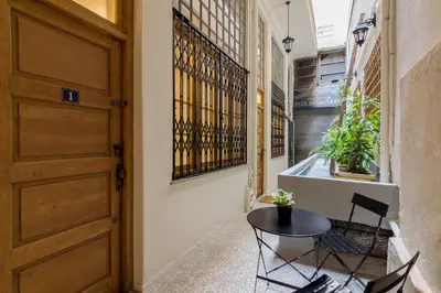 a hallway with a table and chairs and a door at Stoa Kairi Loft A in Athens