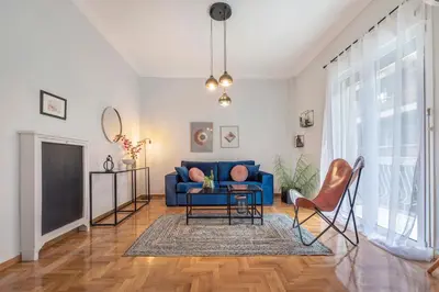 a living room with a blue couch and a table at Luxury 2 bdroom apt- Megaro Mousikis in Athens