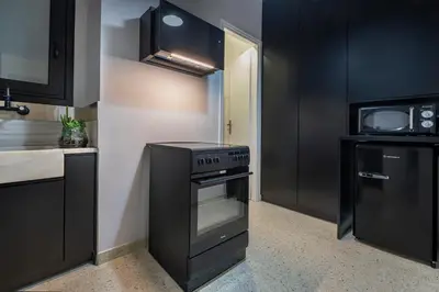 a kitchen with black cabinets and a stove at Luxury 2 bdroom apt- Megaro Mousikis in Athens