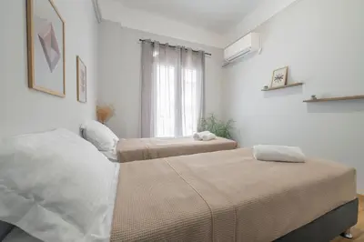 two beds in a white room with a window at Luxury 2 bdroom apt- Megaro Mousikis in Athens