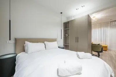a bedroom with a large white bed with white pillows at Aeiphoria Suites & Rooms - Athens in Athens