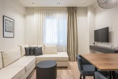 a living room with a white couch and a table at Aeiphoria Suites & Rooms - Athens in Athens