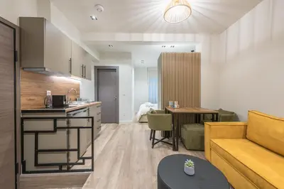 a kitchen and living room with a couch and a table at Aeiphoria Suites & Rooms - Athens in Athens