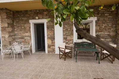 a patio with a table and chairs next to a stone wall at Brand new apartment with hidden garden in Athens