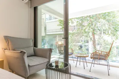 a living room with a chair and a table at Cubes Living Athens Goudi in Athens