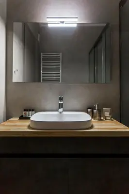 a bathroom with a white sink and a mirror at Cubes Living Athens Goudi in Athens