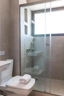 a bathroom with a toilet and a glass shower at Cubes Living Athens Goudi in Athens
