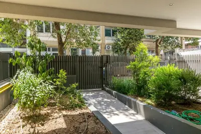 a fence in front of a building with trees at Cubes Living Athens Goudi in Athens