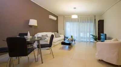 a living room with a table and a couch at Lovely New Βuild Flat Near Metro - Free Parking in Athens