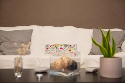a table with a vase and some cookies on a couch at Lovely New Βuild Flat Near Metro - Free Parking in Athens