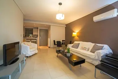 a living room with a couch and a tv at Lovely New Βuild Flat Near Metro - Free Parking in Athens