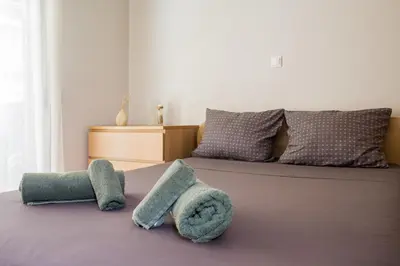 a bedroom with a bed with two towels on the floor at Lovely New Βuild Flat Near Metro - Free Parking in Athens