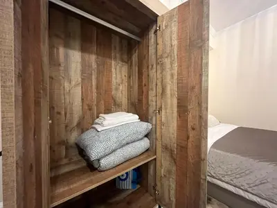 a room with a wooden wall with a bed and towels at Golden Fleece Apartment VIPGreece in Athens