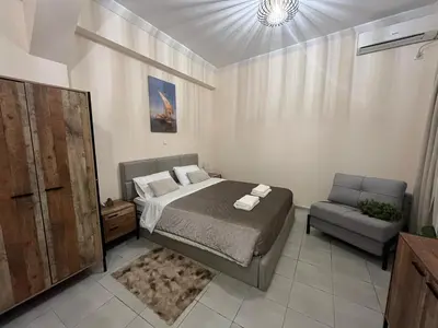 a bedroom with a bed and a chair at Golden Fleece Apartment VIPGreece in Athens