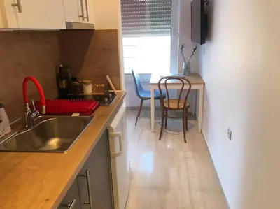 a kitchen with a sink and a table with chairs at Royal Red suite No2 PIRAEUS PORT in Piraeus
