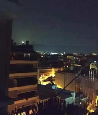 a view of a city at night with lights at Spacious private rooftop studio, mountain and sea view in Athens
