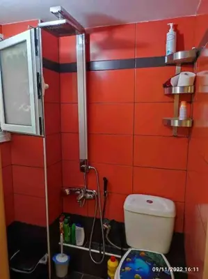 a red tiled bathroom with a toilet and a shower at Spacious private rooftop studio, mountain and sea view in Athens