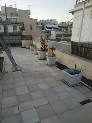 a row of potted plants sitting on a patio at Spacious private rooftop studio, mountain and sea view in Athens