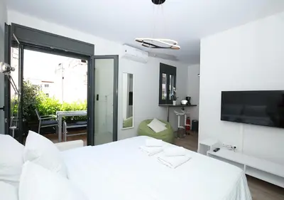 a white bedroom with a white bed and a tv at Emily in Athens - Central chic flat with terrace Syntagma E1 in Athens