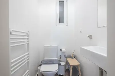 a white bathroom with a toilet and a sink at Stylish 2BDR Apt by the Acropolis in Athens