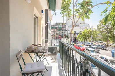 a balcony with chairs and a view of a street at Stylish 2BDR Apt by the Acropolis in Athens
