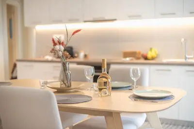 a wooden table with a bottle of wine and glasses at Stylish 2BDR Apt by the Acropolis in Athens