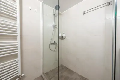 a bathroom with a shower with a glass door at Stylish 2BDR Apt by the Acropolis in Athens
