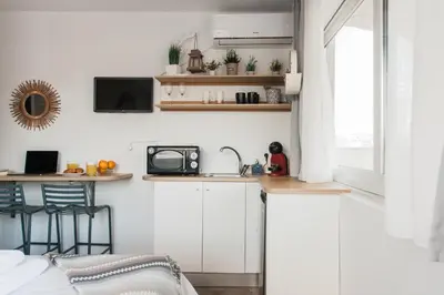 a small kitchen with white cabinets and a sink at Wake up with Acropolis view! in Athens