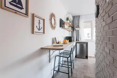 a kitchen with a table and two stools at Wake up with Acropolis view! in Athens