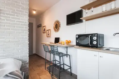 a kitchen with a microwave and a counter with stools at Wake up with Acropolis view! in Athens