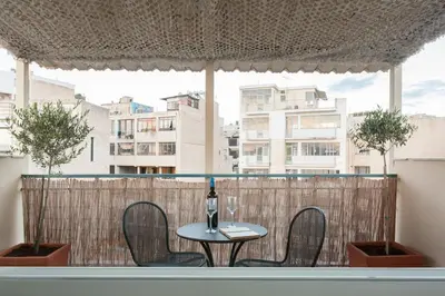 a table and chairs on a balcony with a window at Wake up with Acropolis view! in Athens