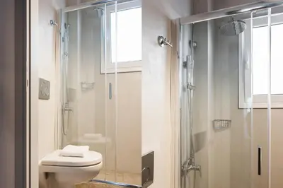 a bathroom with a toilet and a glass shower at Wake up with Acropolis view! in Athens