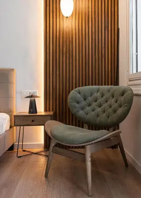 a bedroom with a green chair and a bed at Acropolis Holmes Residence in Athens