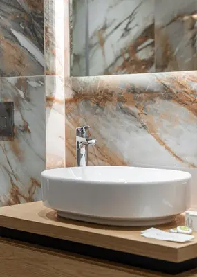 a white sink on a wooden counter in a bathroom at Acropolis Holmes Residence in Athens