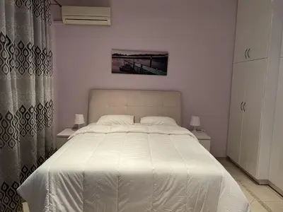 a bedroom with a white bed with two tables and a curtain at Piraeus Cozy Stylish, Fully Reno Apt, near metro in Piraeus