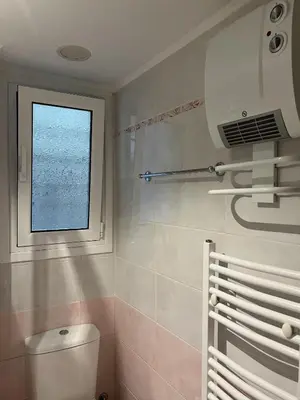 a bathroom with a toilet and a window at Piraeus Cozy Stylish, Fully Reno Apt, near metro in Piraeus