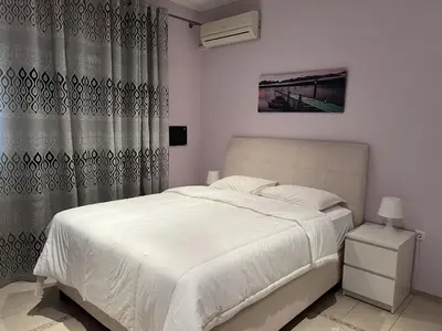 a bedroom with a white bed and a curtain at Piraeus Cozy Stylish, Fully Reno Apt, near metro in Piraeus